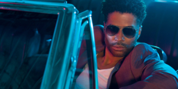 A photo of R&B singer Eric Benét wearing sunglasses while seated in a convertible