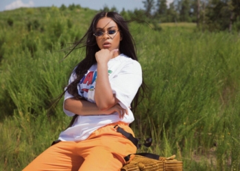 A photo of Koryn Hawthorne sitting in a grassy area outside