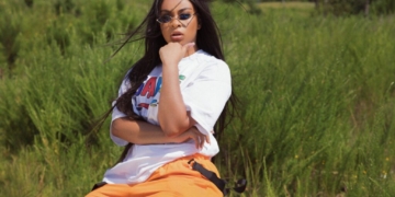 A photo of Koryn Hawthorne sitting in a grassy area outside