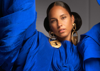 An image of singer Alicia Keys wearing a blue top with gold earrings