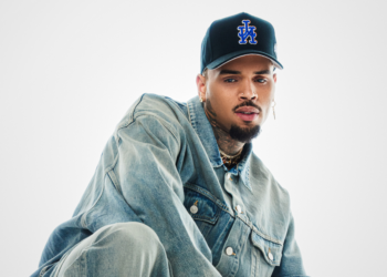 R&B singer Chris Brown poses in front of a plain backdrop