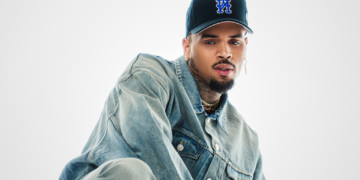 R&B singer Chris Brown poses in front of a plain backdrop