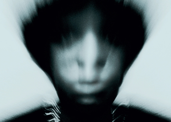 Gallant's Zinc album cover features a blurred portrait of him with an indistinct face, wearing a necklace, set against a dark, monochromatic background, creating a mysterious and eerie atmosphere.