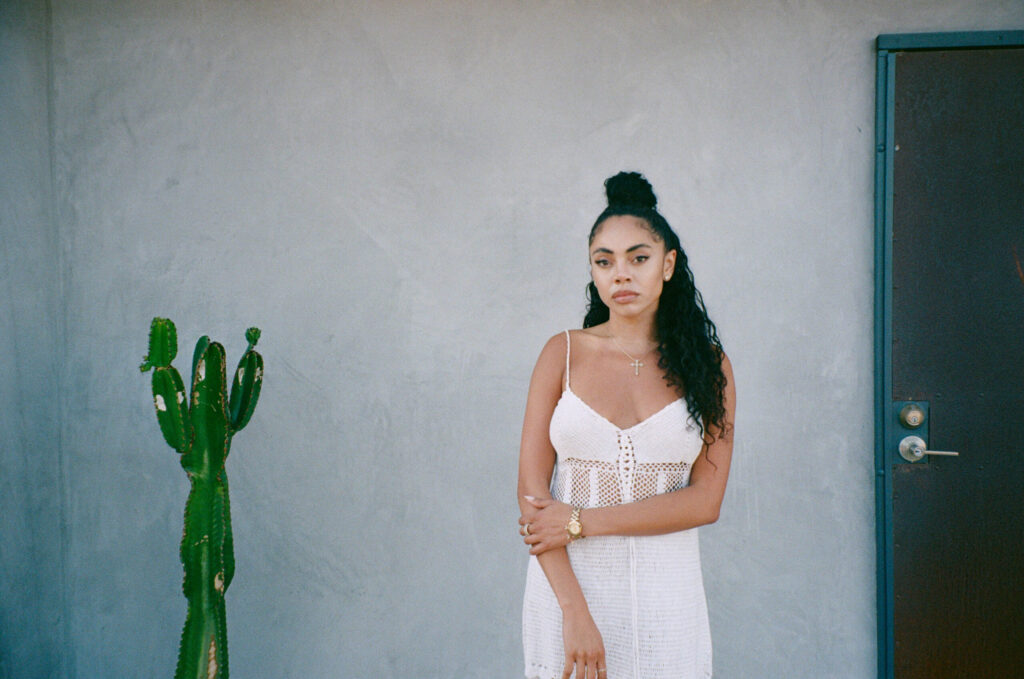 A photo of singer Jaz Karis standing in front of a blank wall.