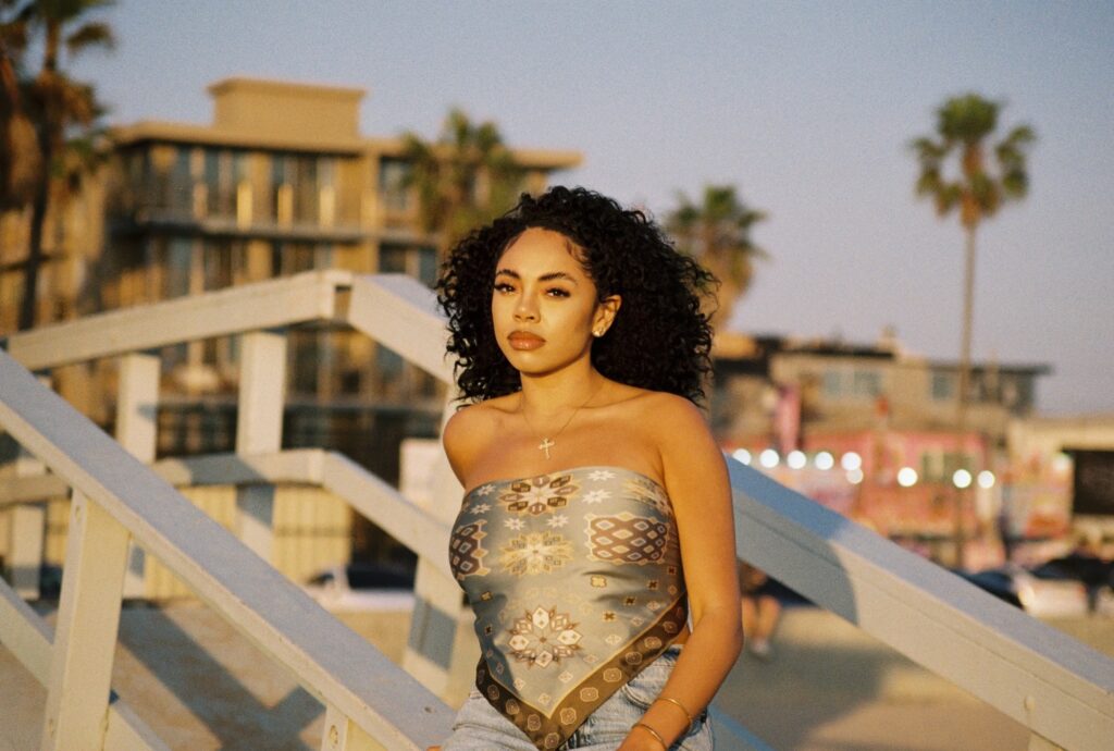 A photo of R&B singer Jaz Karis outside with palm trees in the background