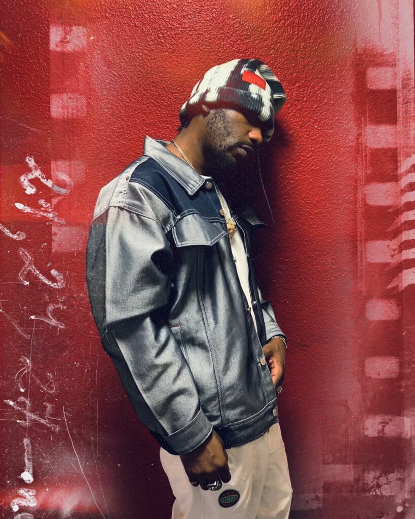 A photo of R&B singer PHABO against a red backdrop