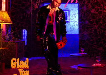 The cover for Mario's album 'Glad You Came,' featuring the artist in a sparkling black outfit, holding a red phone in a dimly lit room with purple and pink lighting.