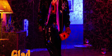 The cover for Mario's album 'Glad You Came,' featuring the artist in a sparkling black outfit, holding a red phone in a dimly lit room with purple and pink lighting.