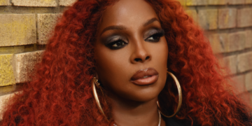 A photo of Mary J. Blige with red hair and gold earrings