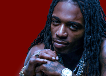 An image of R&B singer Jacquees against a red backdrop