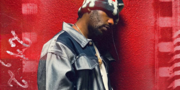 A photo of R&B singer PHABO against a red backdrop