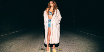 An image of singer Skylar Simone standing in the middle of a street at night time.