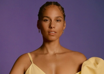 An image of Alicia Keys in front of a purple backdrop.