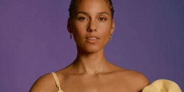 An image of Alicia Keys in front of a purple backdrop.