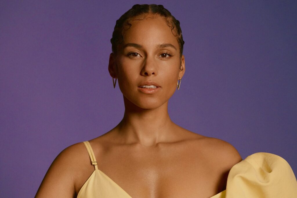 An image of Alicia Keys in front of a purple backdrop.