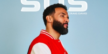 Craig David's SOS single cover: Craig David wearing a red and white varsity jacket, standing against a light blue backdrop