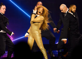 Janet Jackson dazzles in a gold bodysuit, performing on stage with fellow dancers at Resorts World Theatre.