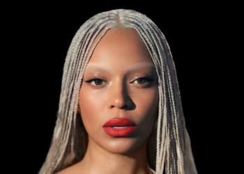 A photo of Beyoncé wearing braids and red lipstick