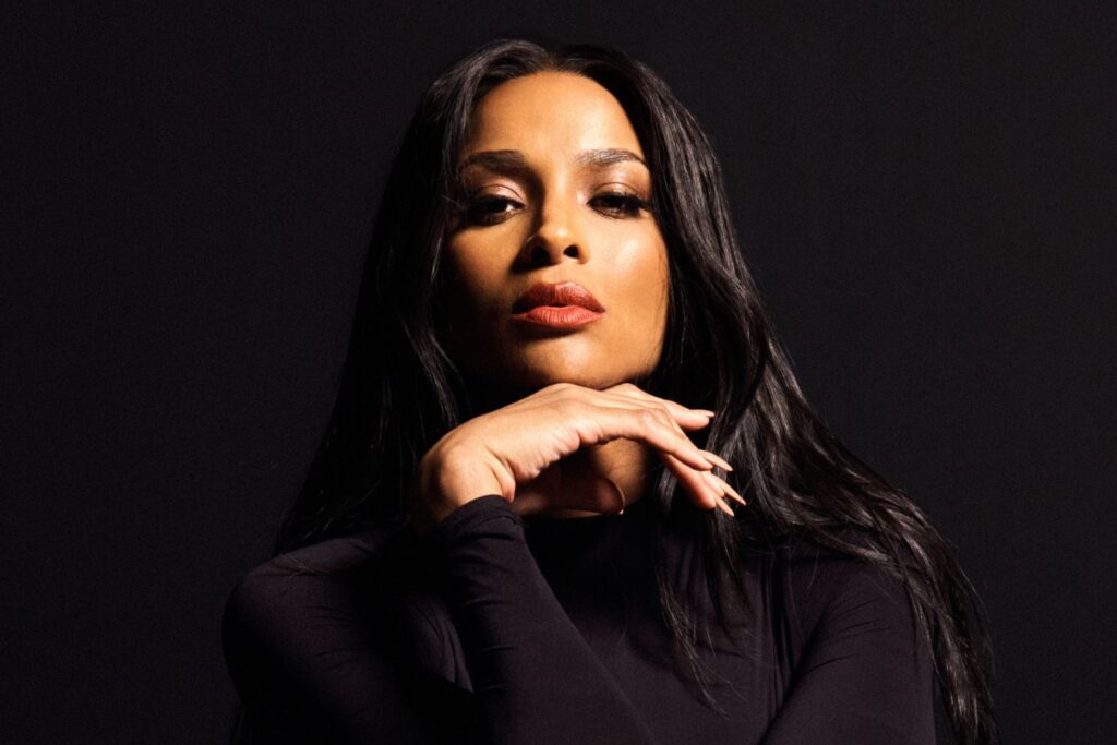 A photo of Ciara wearing black against black background