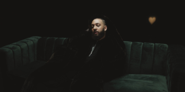 Isaiah Falls sitting on a green couch