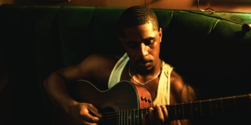 R&B singer Khamari holding a guitar