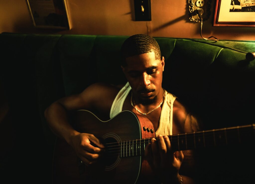 R&B singer Khamari holding a guitar