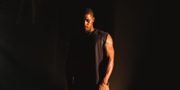 Khamari stands outside in the dark