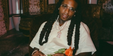 A photo of Jacquees holding a flower