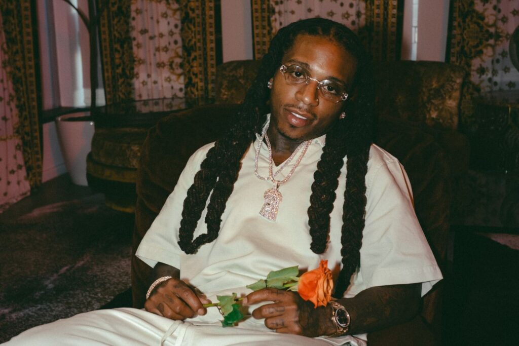 A photo of Jacquees holding a flower