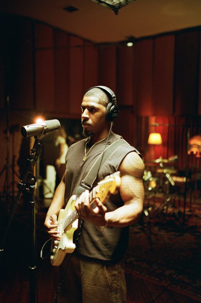 A photo of Khamari holding a guitar