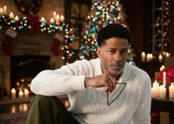 A photo of R&B singer Eric Benet in front of a Christmas tree