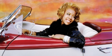 Keyshia Cole in a white and red car