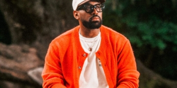 a photo of PJ morton in an orange sweater
