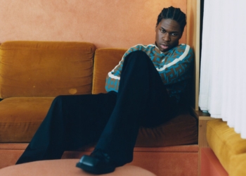 a photo of daniel caesar sitting on a couch