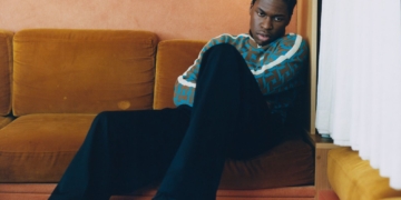 a photo of daniel caesar sitting on a couch